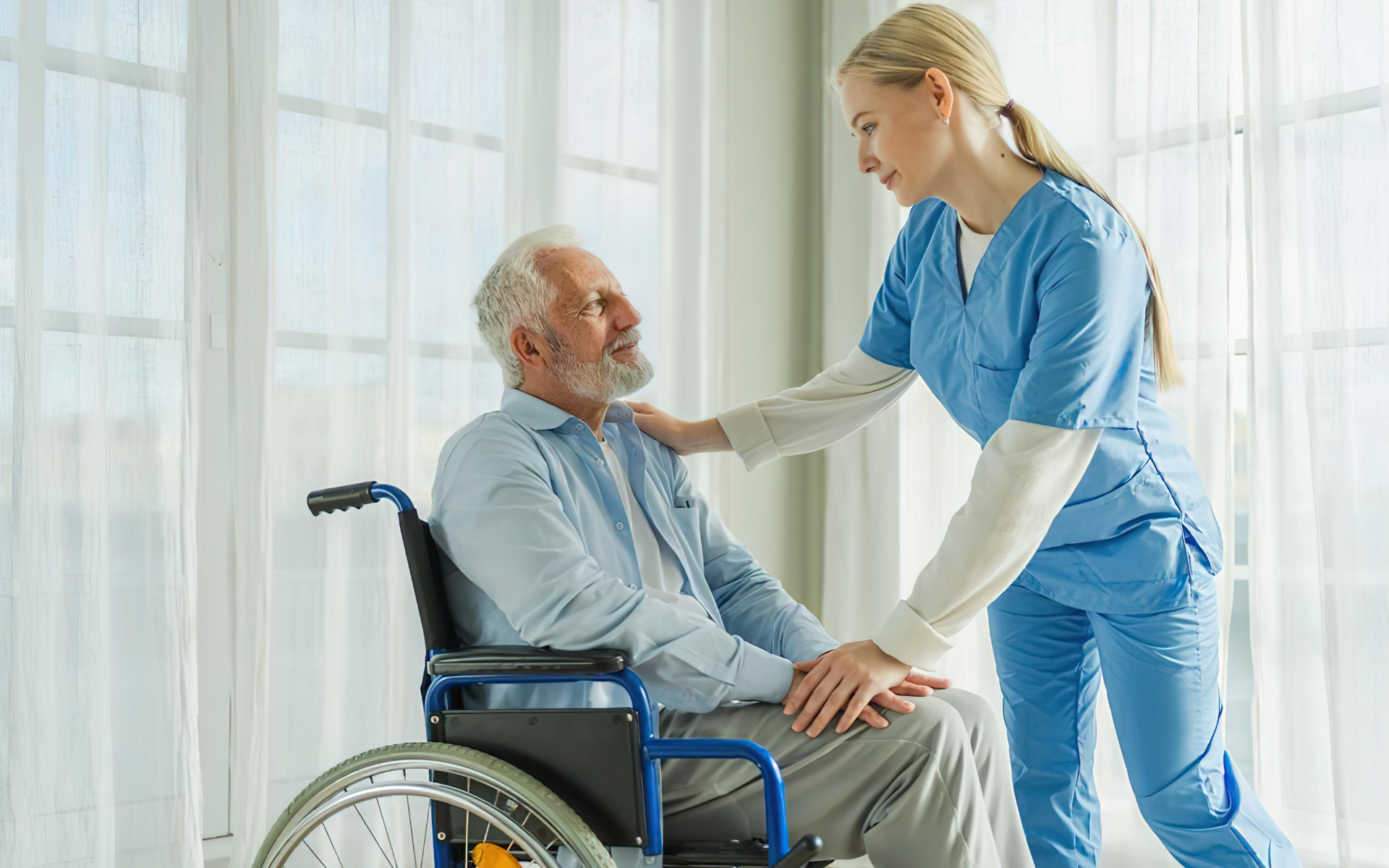 Nurse helping an elderly man in a wheelchair